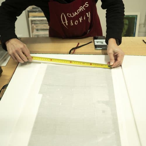 Taller de enmarcación de Cuadros Asorey midiendo una obra en Santiago de Compostela