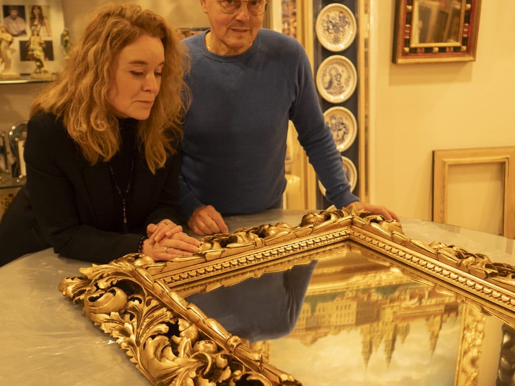Equipo de Cuadros Asorey mostrando un marco dorado en la tienda de Santiago